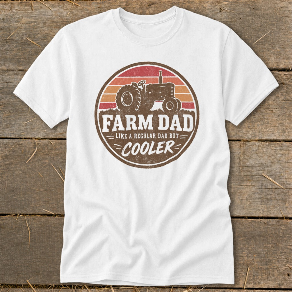 A white t-shirt featuring a circular retro graphic with a tractor and the text FARM DAD LIKE A REGULAR DAD BUT COOLER.