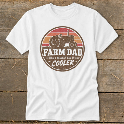 A white t-shirt featuring a circular retro graphic with a tractor and the text FARM DAD LIKE A REGULAR DAD BUT COOLER.