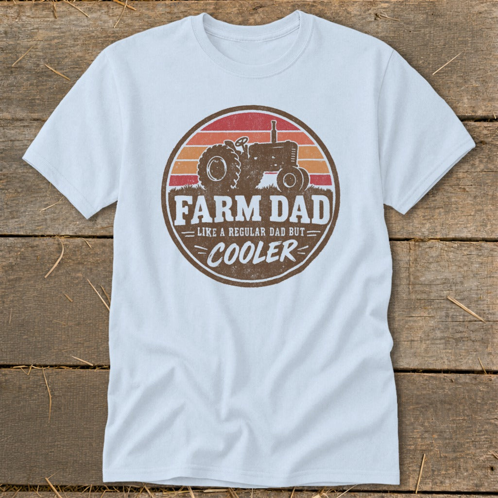 A light blue t-shirt with a vintage tractor graphic and the text FARM DAD LIKE A REGULAR DAD BUT COOLER.