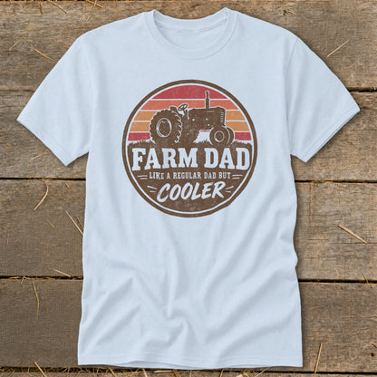 A light blue t-shirt with a vintage tractor graphic and the text FARM DAD LIKE A REGULAR DAD BUT COOLER.