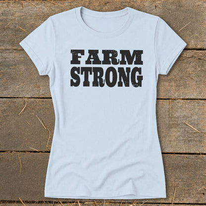 Light blue women's t-shirt featuring the distressed black text FARM STRONG displayed across the chest.