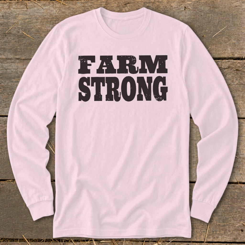 A light pink long-sleeve t-shirt with the words Farm Strong printed in black distressed lettering across the chest.