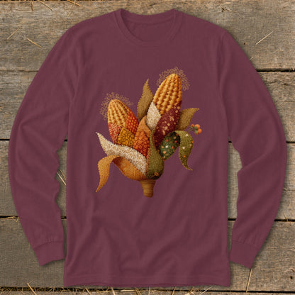 Maroon long-sleeve shirt with a colorful corn cob illustration featuring patchwork fabric textures.