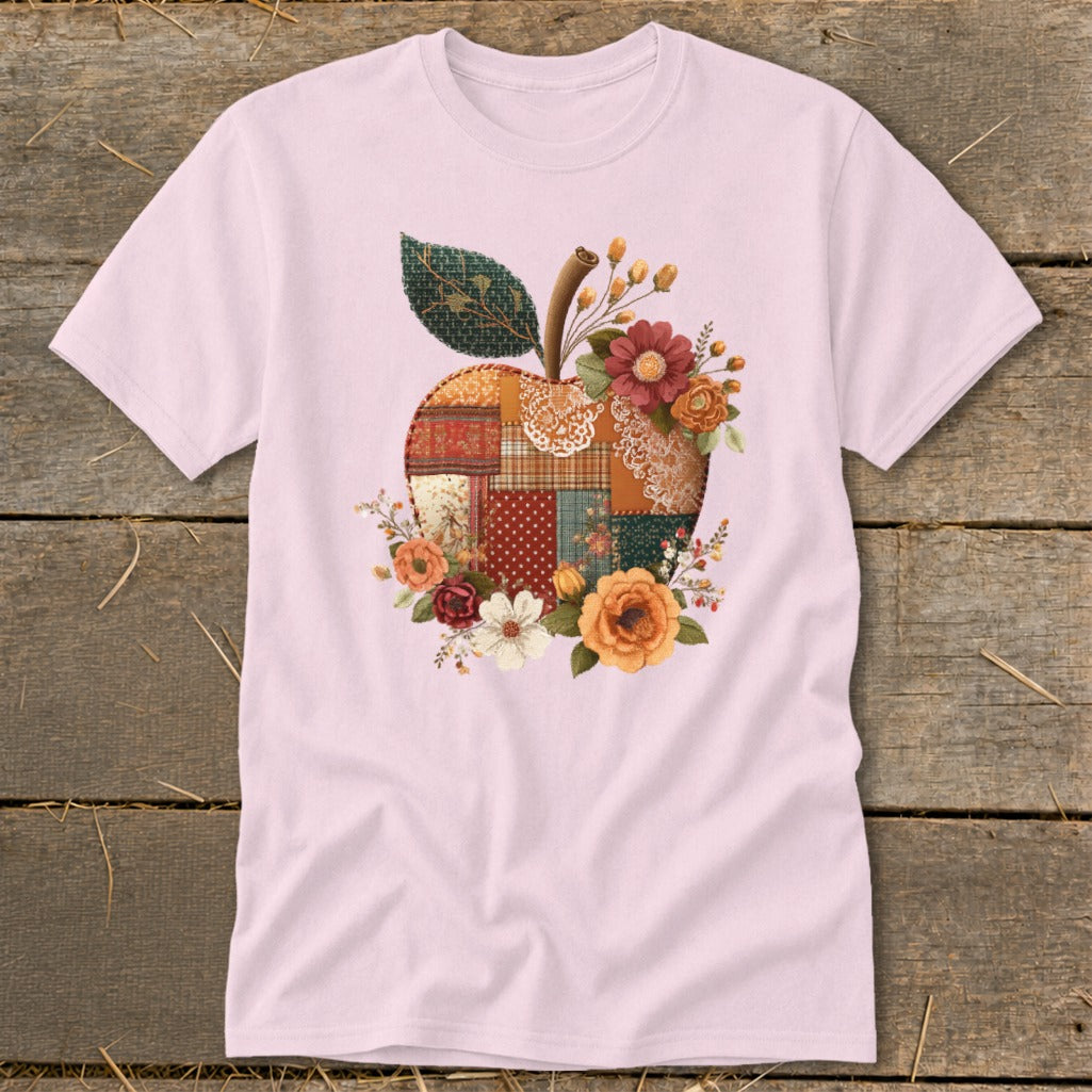 Pink t-shirt with a patchwork apple design featuring flowers and a leaf.