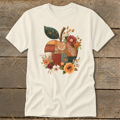 Cream t-shirt with a patchwork apple graphic surrounded by flowers.