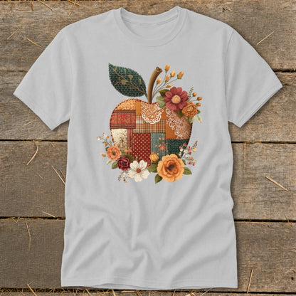 Light grey t-shirt with a patchwork apple design with flowers and leaves.