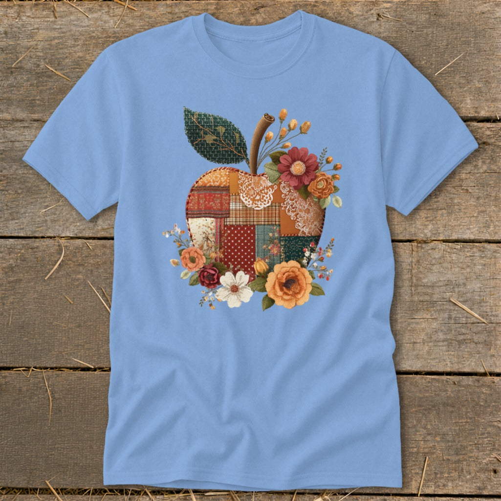 Light blue t-shirt with a patchwork apple design featuring flowers.