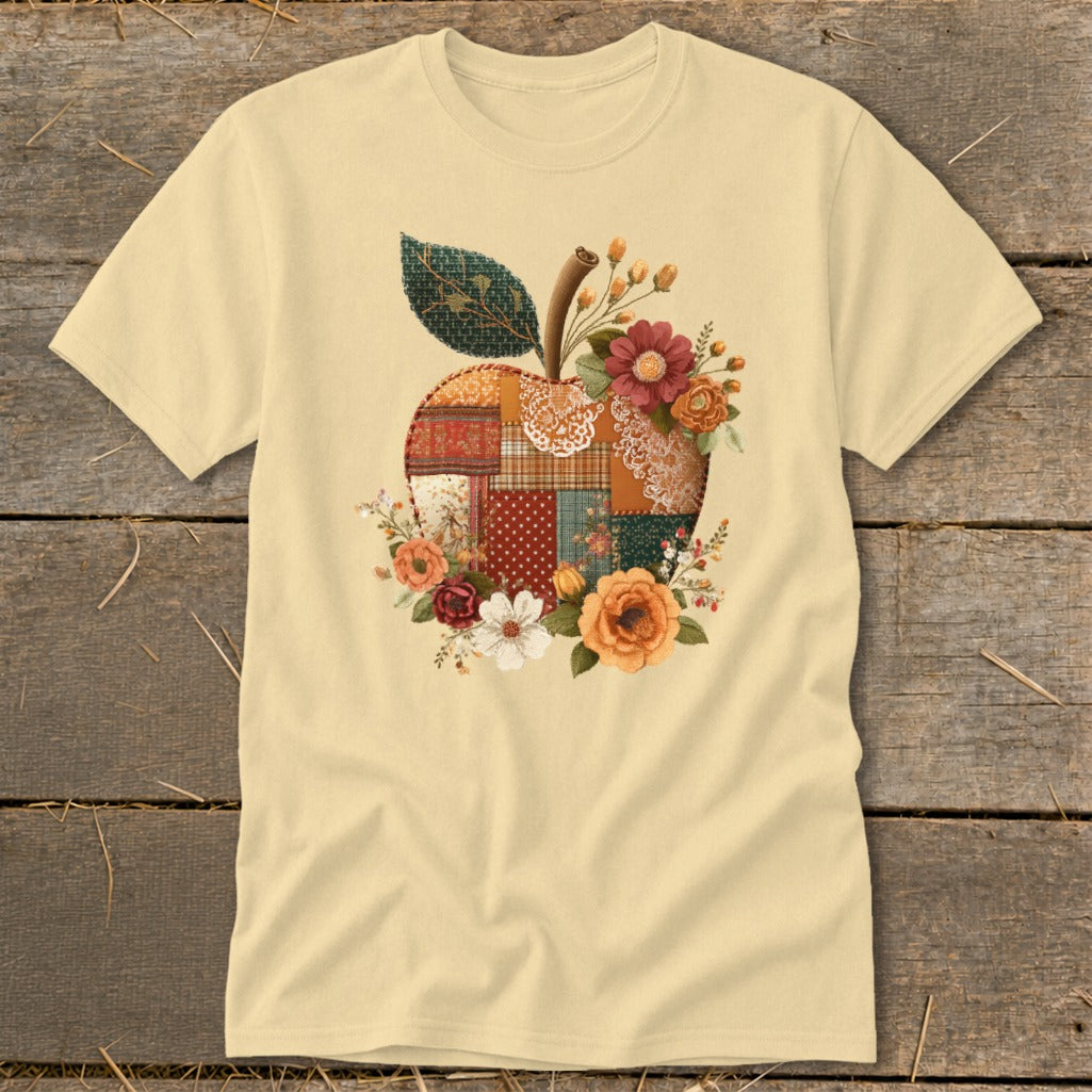 Light yellow t-shirt with a patchwork apple design and floral accents.