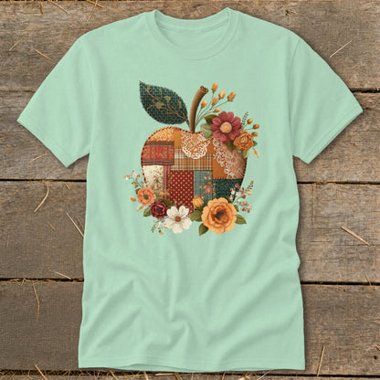 Mint t-shirt with a patchwork apple graphic surrounded by flowers.