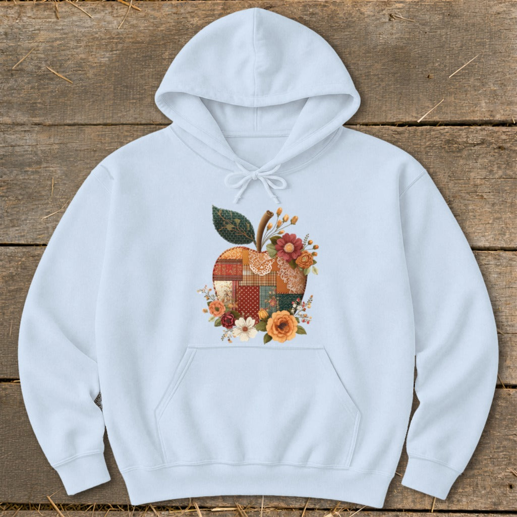 Light blue hoodie with a patchwork apple and floral graphic.