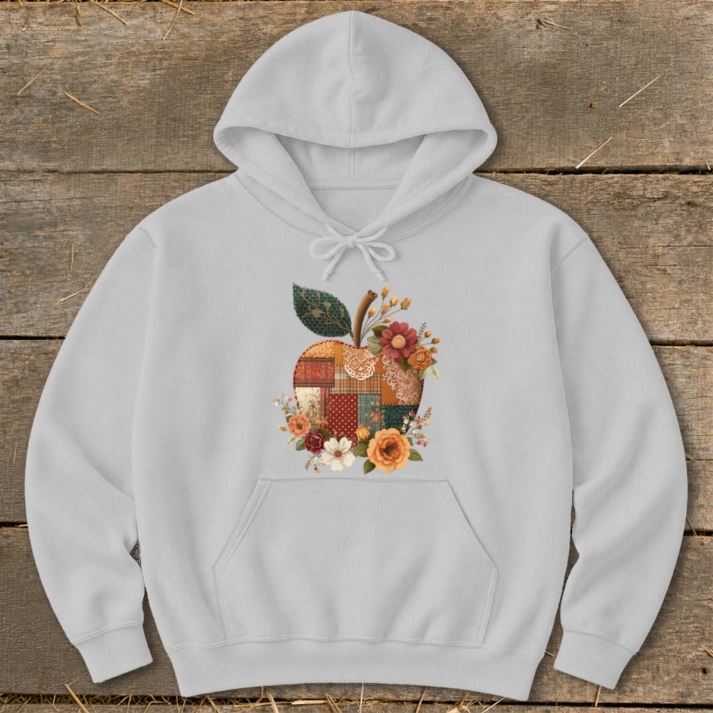 Light grey hoodie with a patchwork apple graphic surrounded by flowers.