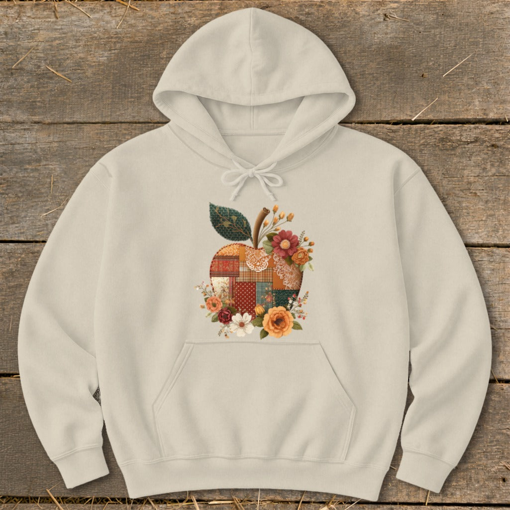 Cream hoodie with a patchwork apple design and floral accents.