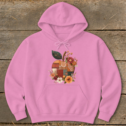 Pink hoodie with a patchwork apple design surrounded by flowers.