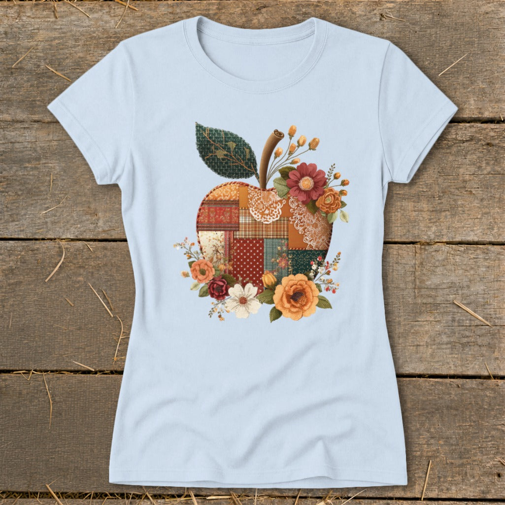 Light blue t-shirt with a patchwork apple design adorned with flowers.