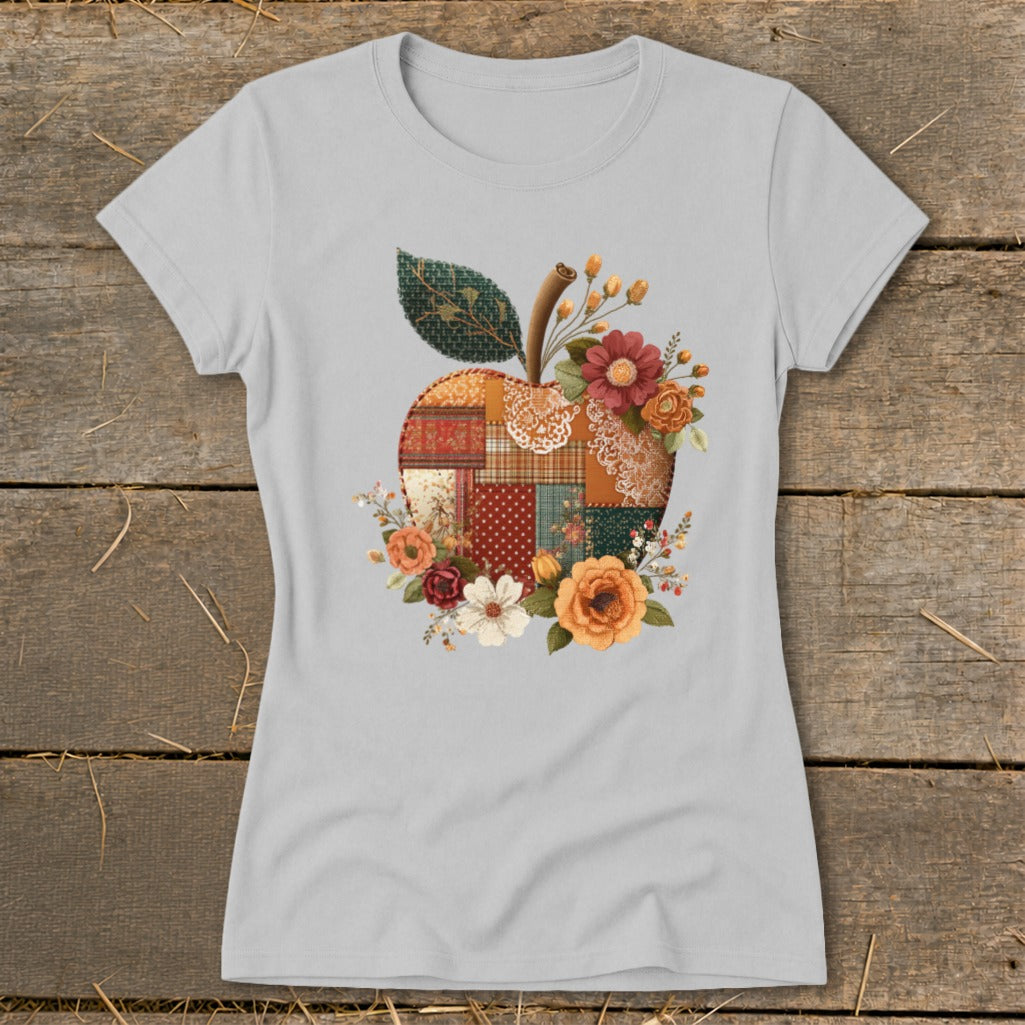 Gray t-shirt with a patchwork apple design surrounded by flowers.