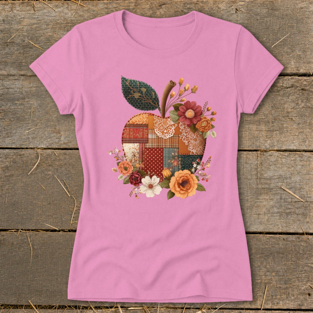 Pink t-shirt with a patchwork apple design featuring flowers and a leaf.