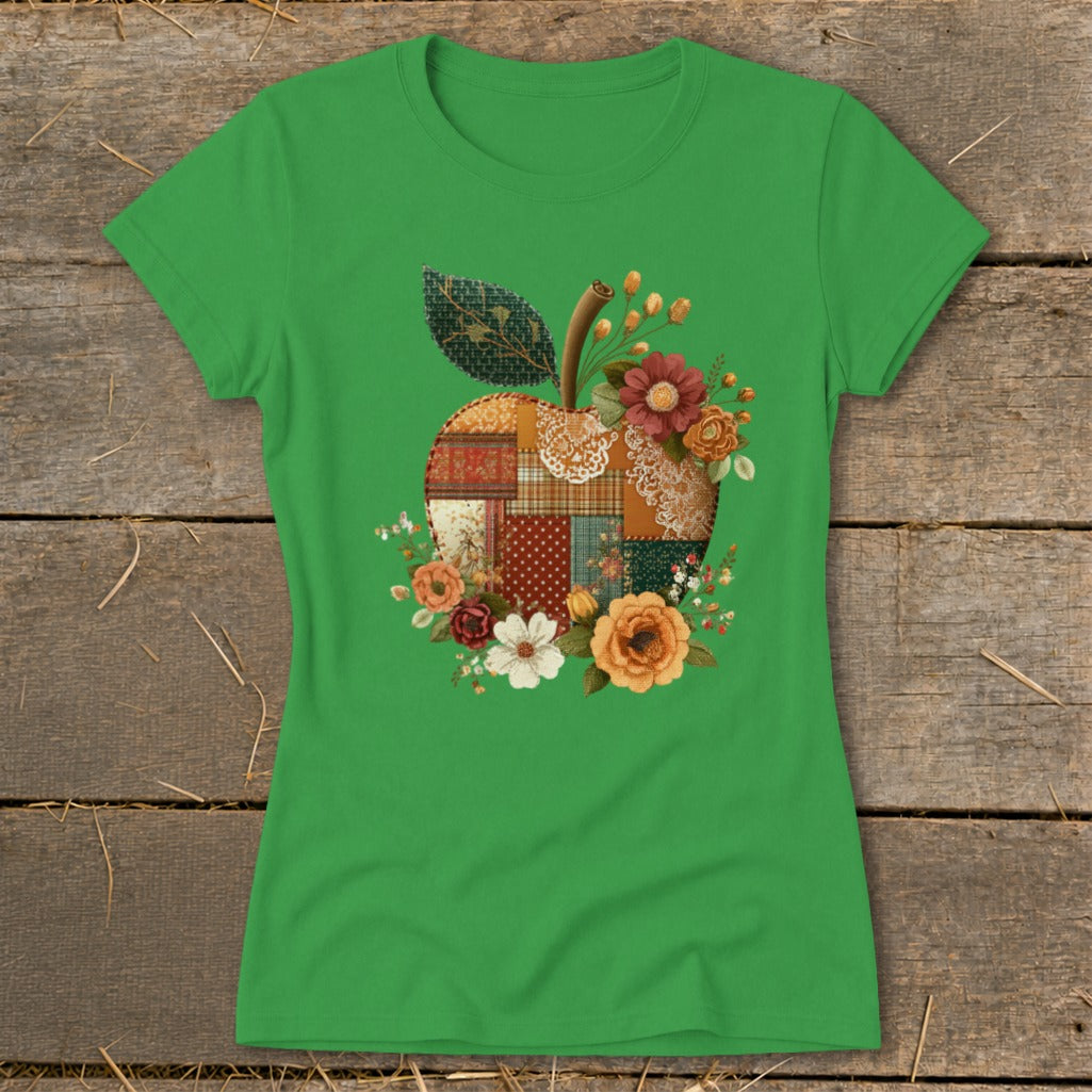 Green t-shirt with a patchwork apple graphic surrounded by flowers.
