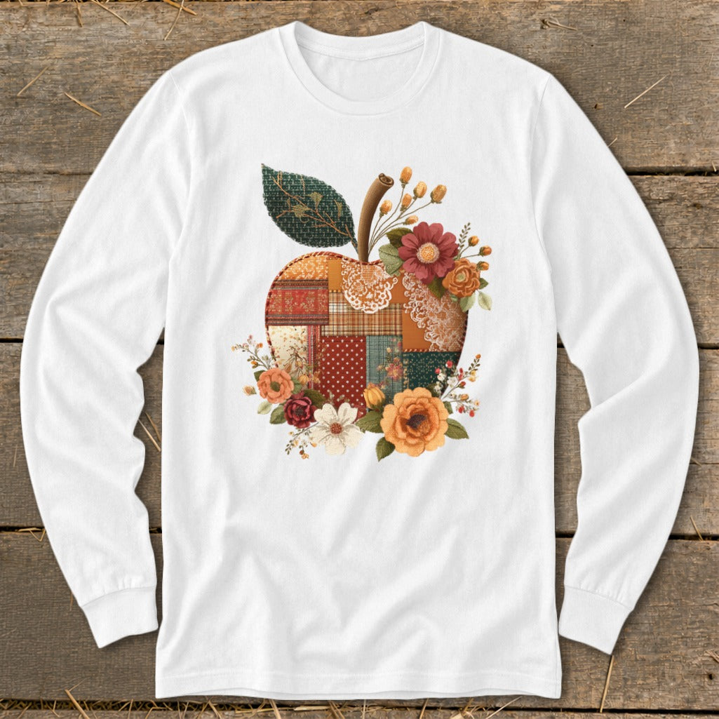 White long-sleeved shirt with a patchwork apple adorned with autumn flowers and leaves.