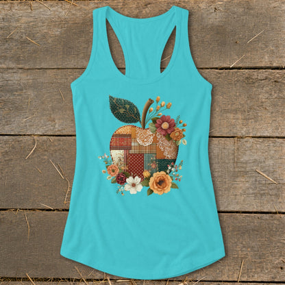 Teal tank top with a patchwork apple graphic surrounded by flowers.