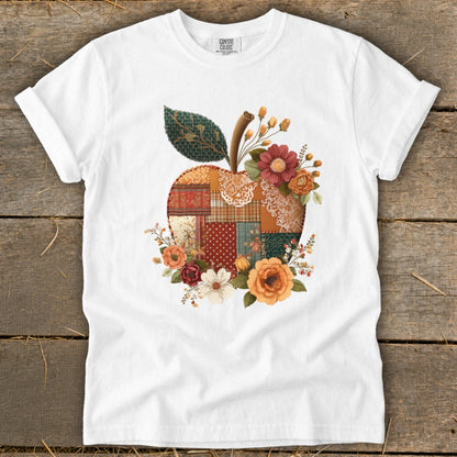 White t-shirt with a patchwork apple design adorned with flowers.