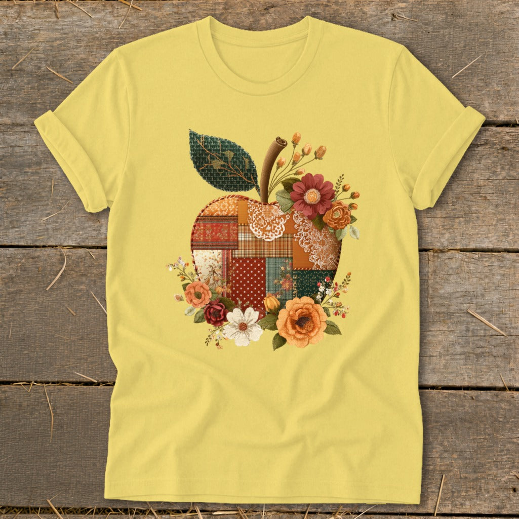 Yellow t-shirt with a patchwork apple graphic adorned with flowers and a leaf.