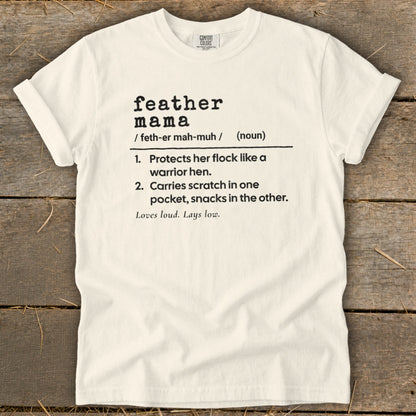 White t-shirt with black text defining "feather mama" and its characteristics.