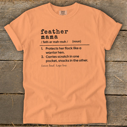 Orange t-shirt with "feather mama" definition and phrases: "Loves loud. Lays low."