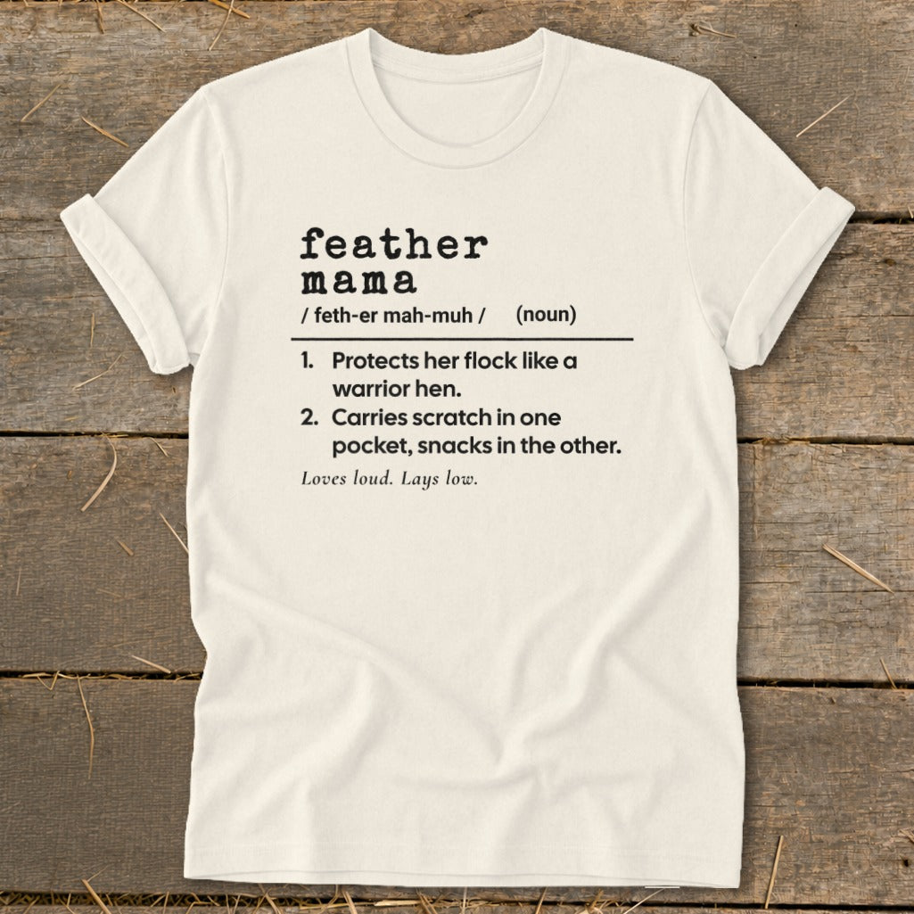 Cream t-shirt with "feather mama" definition printed in black text.