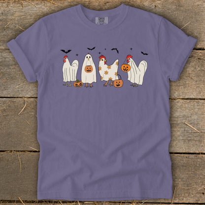 Purple t-shirt with Halloween-themed chickens and pumpkins graphic and bats above.