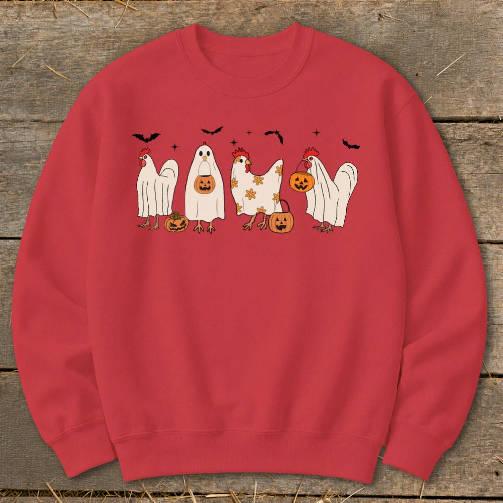 Four chickens, some dressed as ghosts, hold pumpkins and stand near bats.