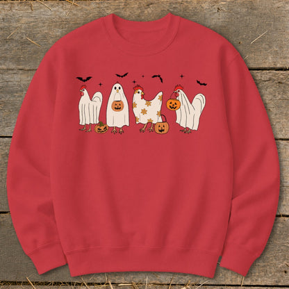 Four chickens, some dressed as ghosts, hold pumpkins and stand near bats.