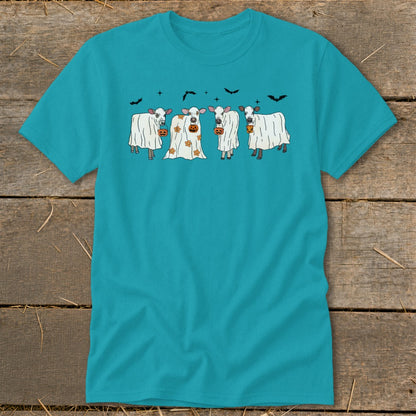 Four cows dressed as ghosts hold pumpkins under a sky with bats.