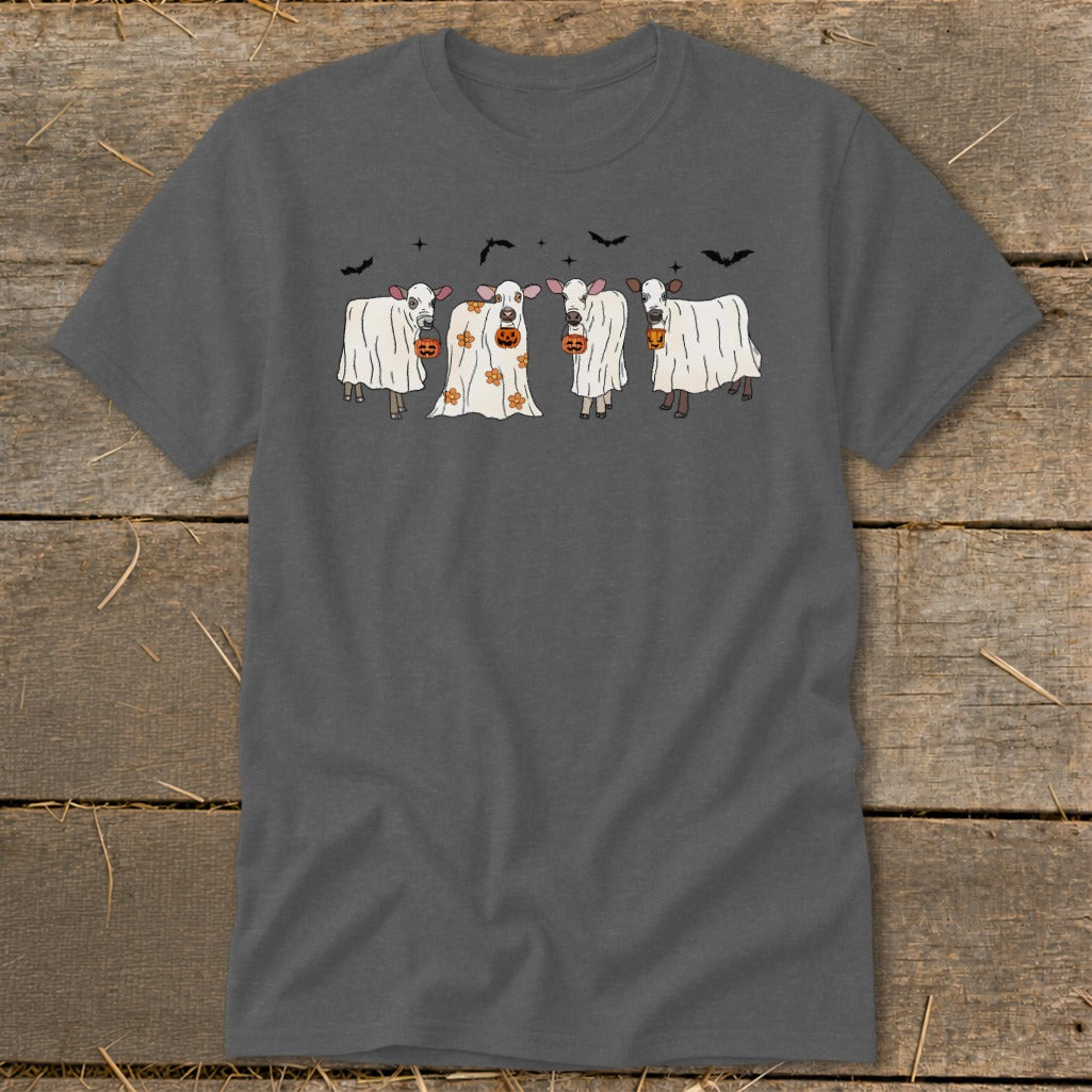Four cows in ghost costumes with pumpkins stand under bats and stars.
