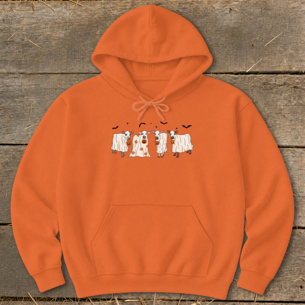 Orange hoodie with a Halloween graphic of cows dressed as ghosts and pumpkins.