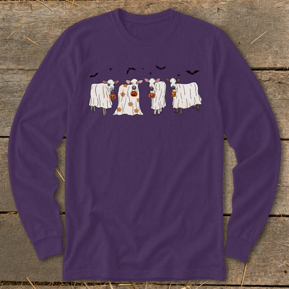 Four cows dressed as ghosts with pumpkins and bats for Halloween.