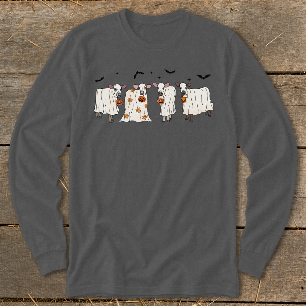 Four cows in ghost costumes hold pumpkins with bats and stars above.
