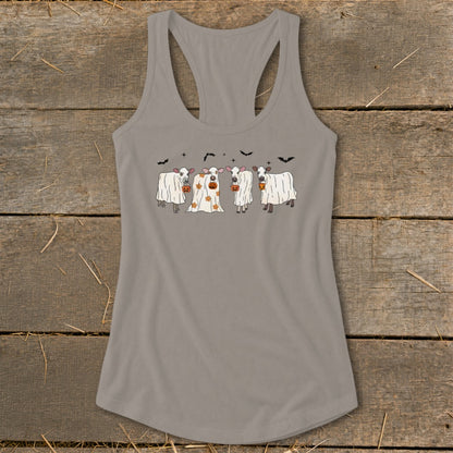 Four cows dressed as ghosts with pumpkins and bats for Halloween.