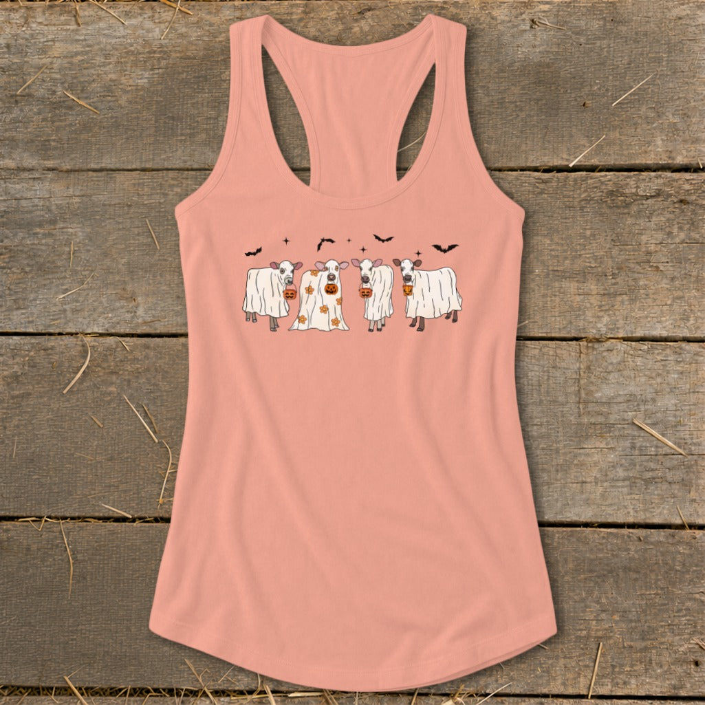 Four cows dressed as ghosts with pumpkins for Halloween on a peach tank top.