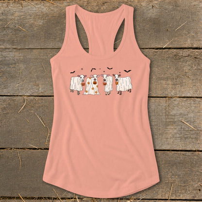 Four cows dressed as ghosts with pumpkins for Halloween on a peach tank top.