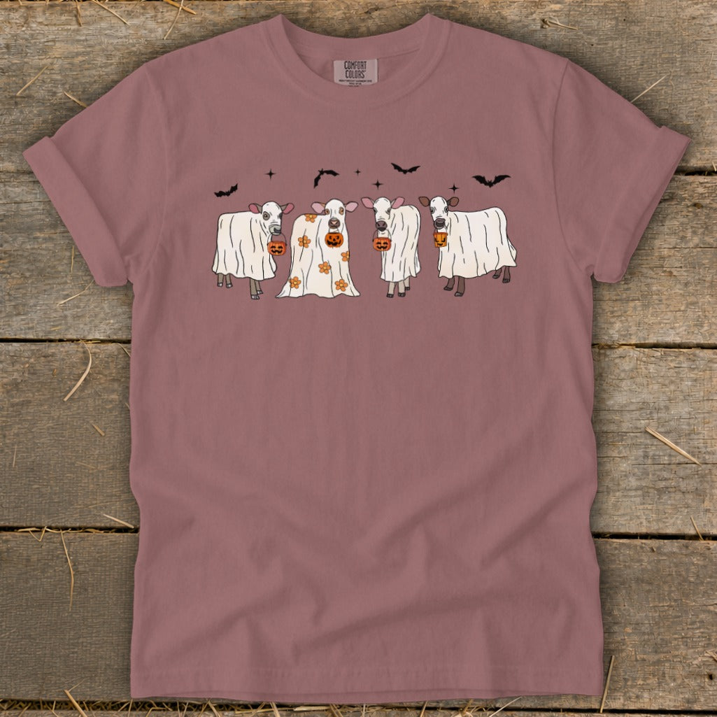 Four cows in ghost costumes with pumpkins, bats, and stars.