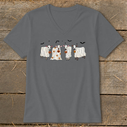 Four cows dressed as ghosts with pumpkins and bats for Halloween.