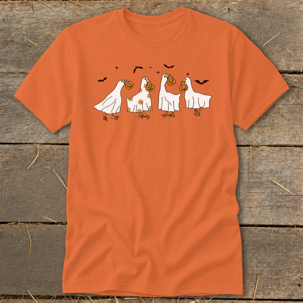 Orange t-shirt with four white ghost-like figures holding pumpkins and bats flying above.