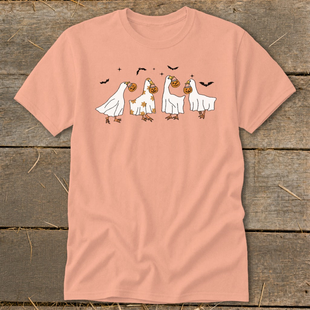 Four ducks in ghost costumes holding jack-o'-lanterns with bats flying above.