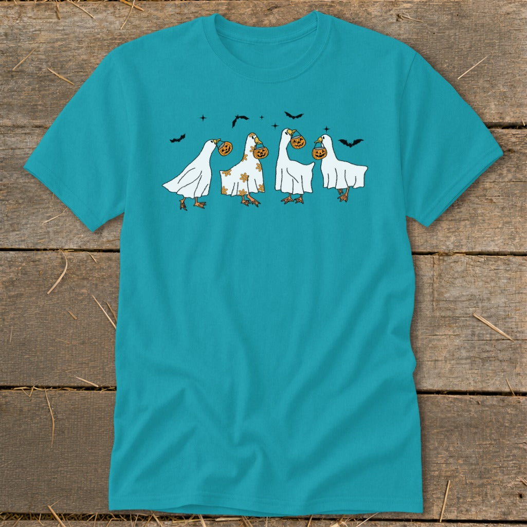 Four white geese in ghost costumes holding pumpkins, with bats above.
