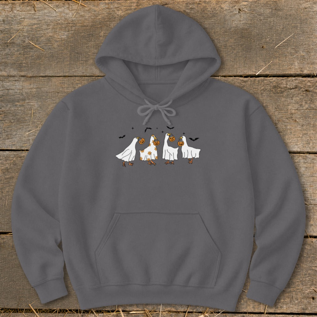 Four ducks dressed as ghosts holding pumpkins with bats above.