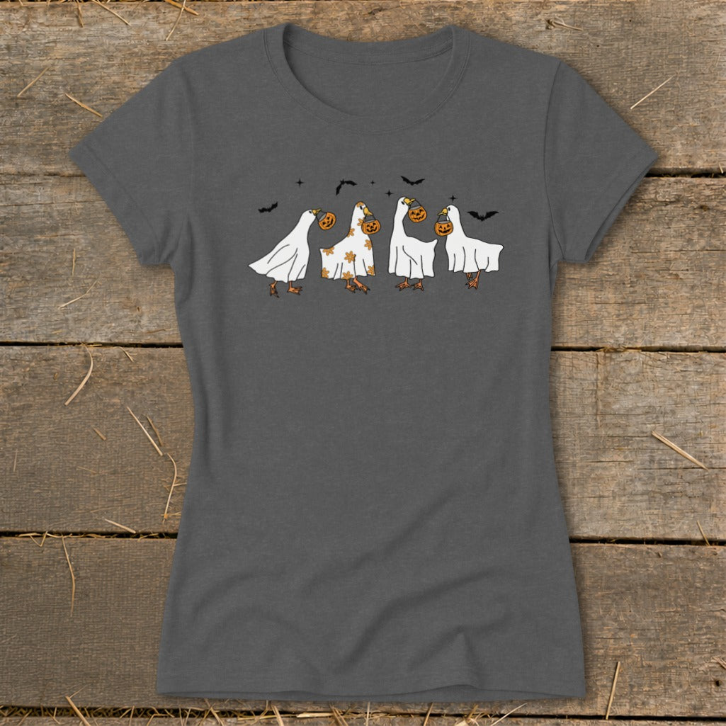 Four geese in ghost costumes holding jack-o'-lanterns with bats overhead.