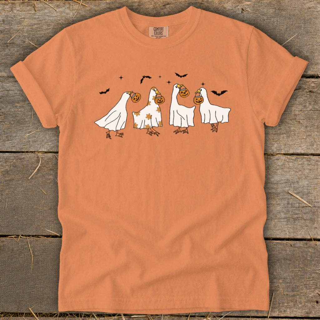 Orange t-shirt with four ghost-like ducks trick-or-treating and bats.