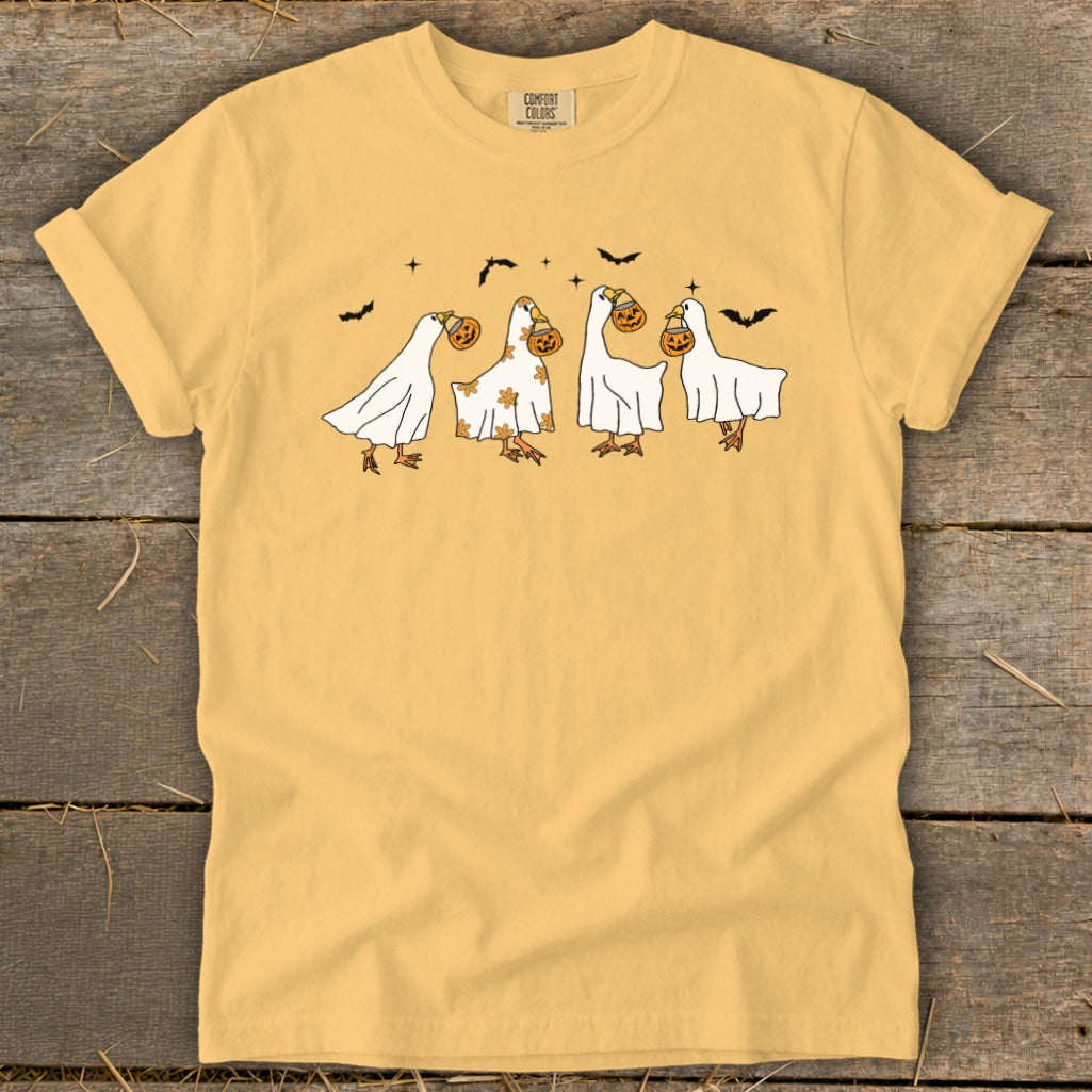 Four geese in ghost costumes holding jack-o'-lanterns, with bats above.