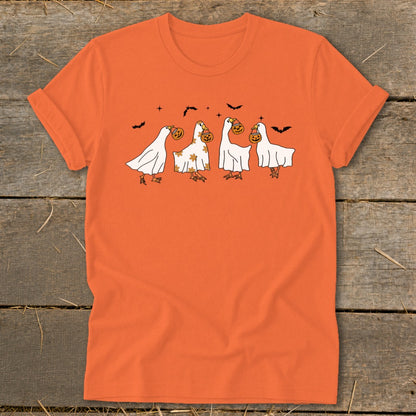 Orange t-shirt with a graphic of four geese dressed as ghosts holding pumpkins.