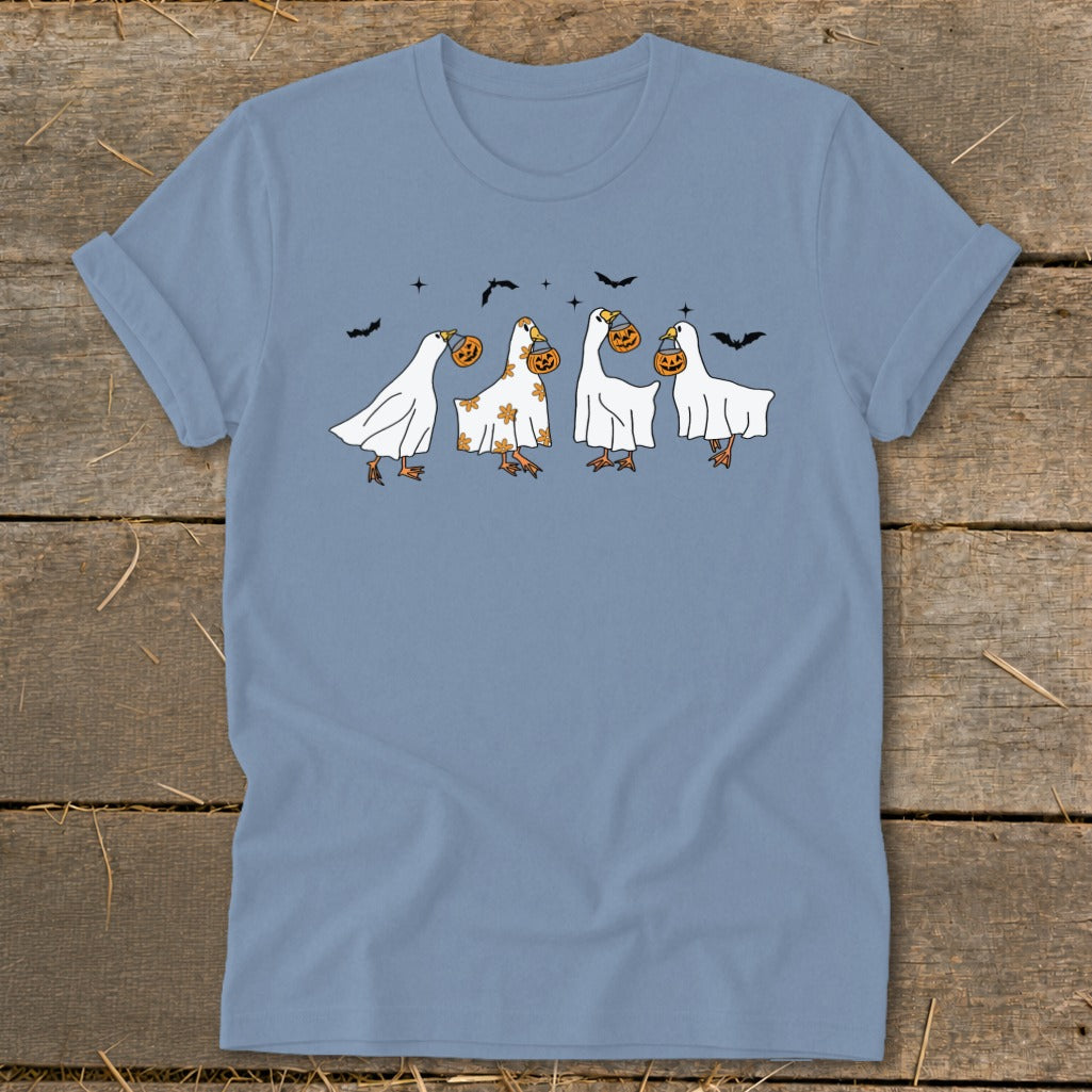 Four geese dressed as ghosts carry pumpkins while bats fly above.